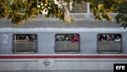 Varios migrantes se asoman por las ventanillas de un tren en la estación de ferrocarril en Cakovec, Croacia, hoy, 17 de octubre, cerca de la frontera con Eslovenia.