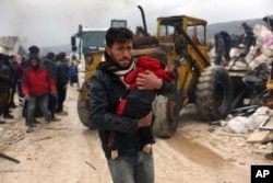 Un hombre carga el cuerpo de un niño que murió a causa de un sismo en la localidad de Besnia, en la provincia de Idlib, Siria, el lunes 6 de febrero de 2023.