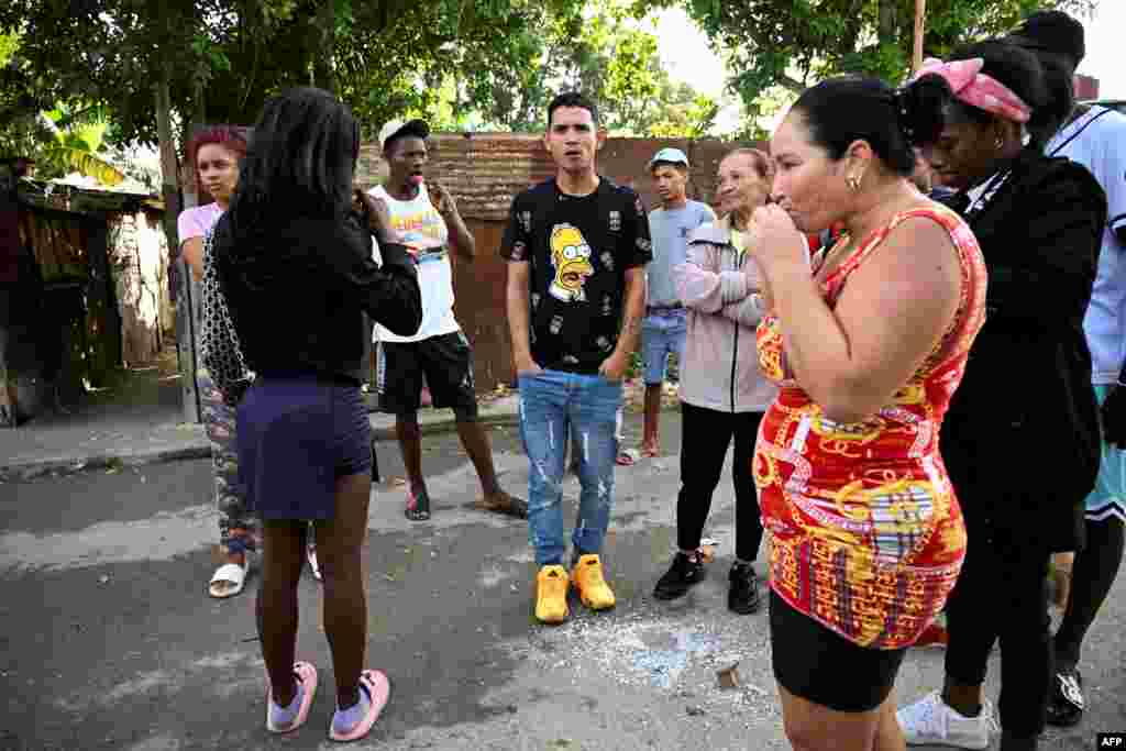 Marlon Brando Díaz (C), encarcelado por su participación en las protestas antigubernamentales de julio de 2021, observa mientras saluda a sus familiares después de ser liberado de la prisión en el barrio de Güinera en La Habana el 16 de enero de 2025.